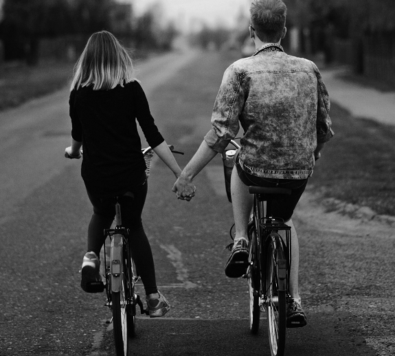 a couple holding hands while riding their bikes, symbolizing good relationship rules