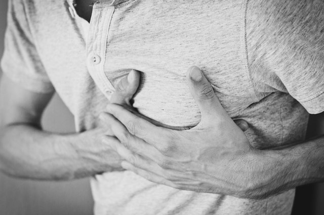 man holding his hands in front of his chest, symbolizing what does it mean to be vulnerable in a relationship