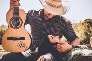 a man with cowboy hat and a guitar sitting on a bench, how to get sex right now