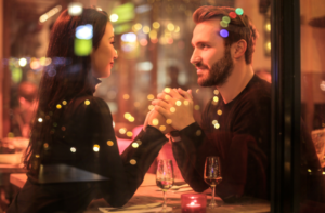 man and woman sitting in a restaurant, holding hands, how to get sex right now